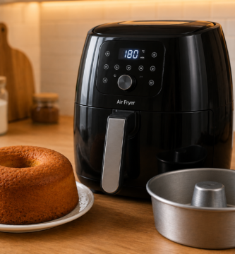 Air fryer para fazer bolos com forma e bolo caseiro sobre bancada de cozinha